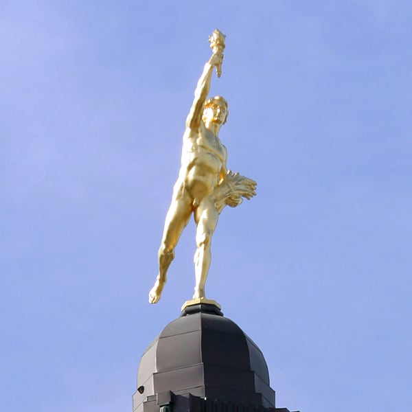 A photograph of the Manitoba Legislative Building’s Golden Boy statue under a clear sky.